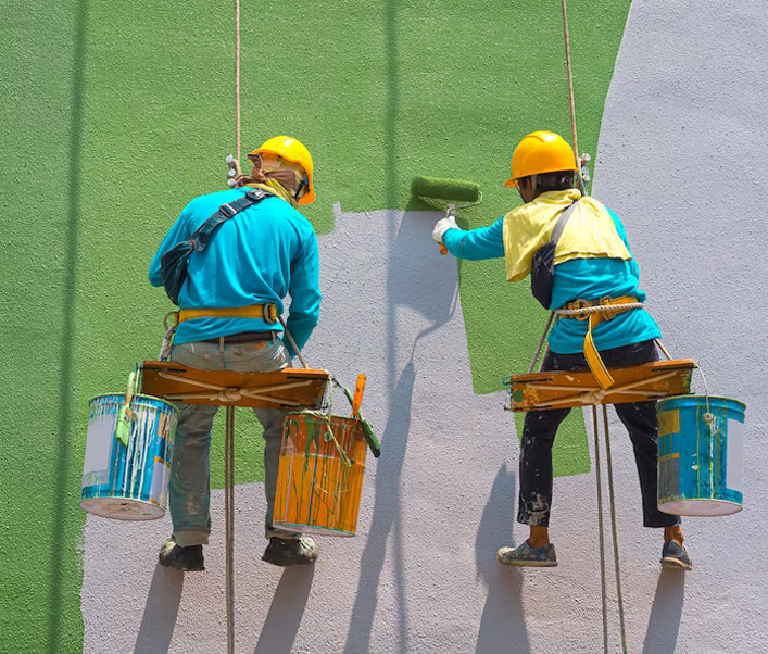 Two men painting the outside of a commercial building